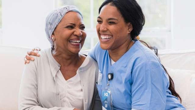 女癌症患者与护士手牵着手大笑