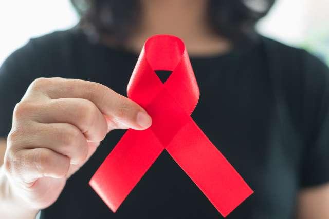 手持红丝带的妇女庆祝世界艾滋病日